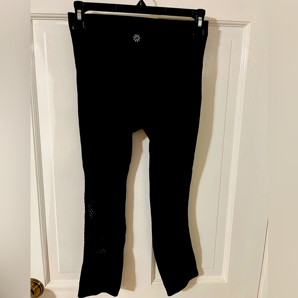 Size XS Athleta black crop leggings with cutouts on lower leg. VGUC